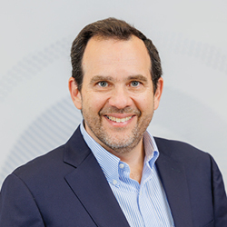 Headshot photograph of smiling man.