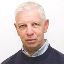 Headshot photograph of white man with white hair.