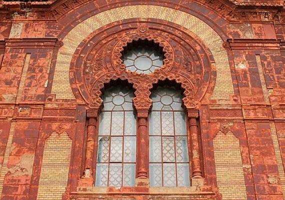 red and yellow brick wall of synagogue with decorative windows