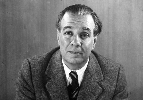black and white photograph of seated middle-aged man wearing a suit jacket