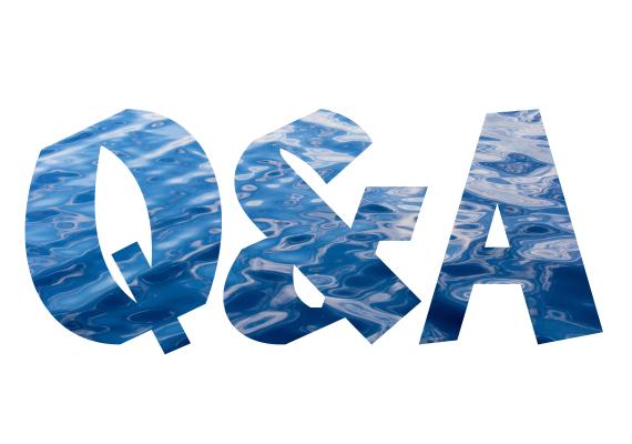 Photograph of rippling water visible through the letters Q and A.