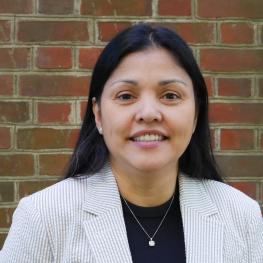 Woman wearing a white blazer over a dark shirt