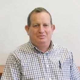 Photograph of older man wearing collared shirt with a pen  in the front shirt pocket.