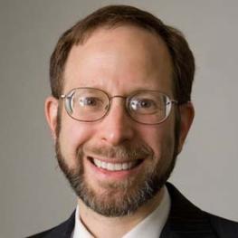 Photograph of smiling man wearing glasses.