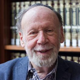 Headshot photograph of smiling elderly man.