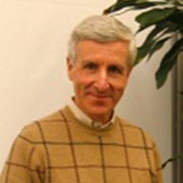 Older man wearing a patterned sweater.
