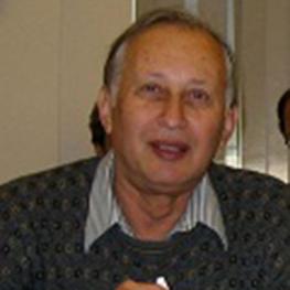 Snapshot photograph of elderly man speaking.